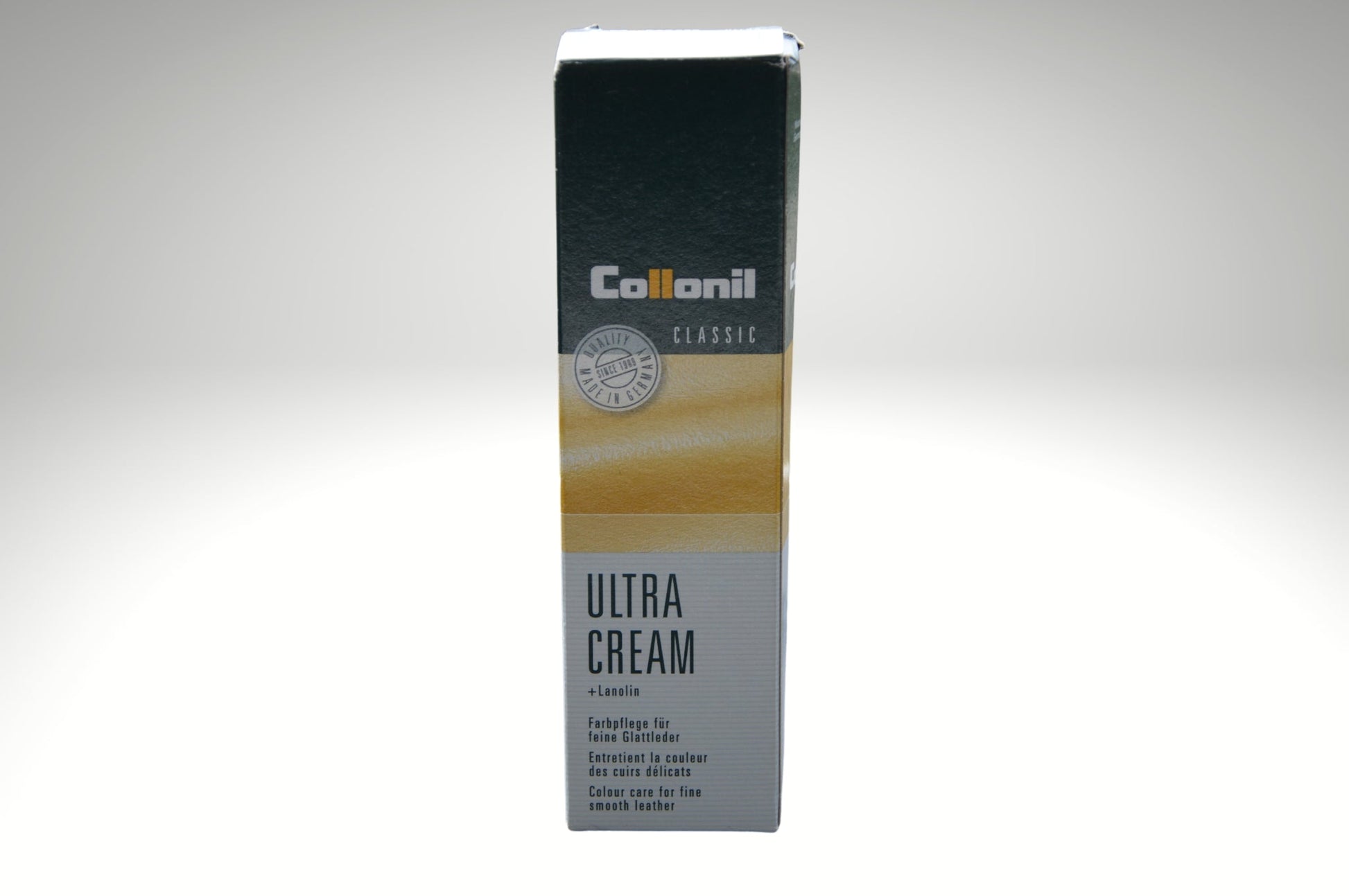 Ein Tubus der Collonil Ultra Cream befindet sich in seiner Verpackung auf einem weißen Hintergrund mit leichtem Farbverlauf. Die Verpackung ist gut sichtbar und zeigt die Produktinformationen sowie das Design der Marke.
